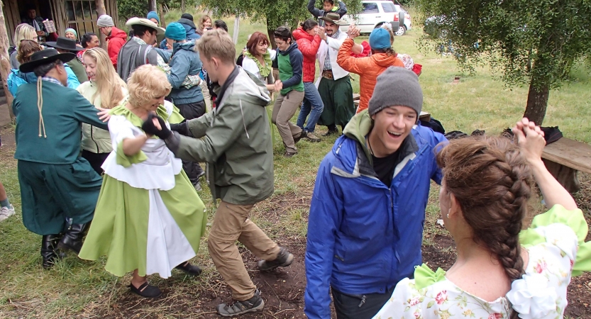 A group of people dance outdoors.